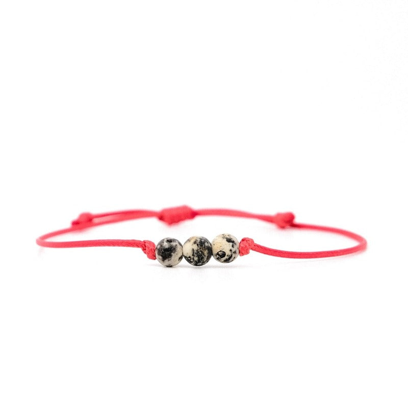 Bracelet cordon rouge et ambre gris par Orbaltic